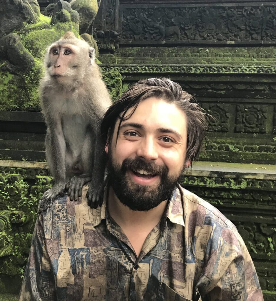 Psilocybin Oregon facilitator Jadryn smiling with a monkey perched on his shoulder, known for supporting deep psilocybin experiences that help with Treatment-Resistant Depression, PTSD, OCD, and major life transitions. Based at Vital Reset, he brings trauma-informed care and personalized psilocybin treatment with sliding scale pricing.