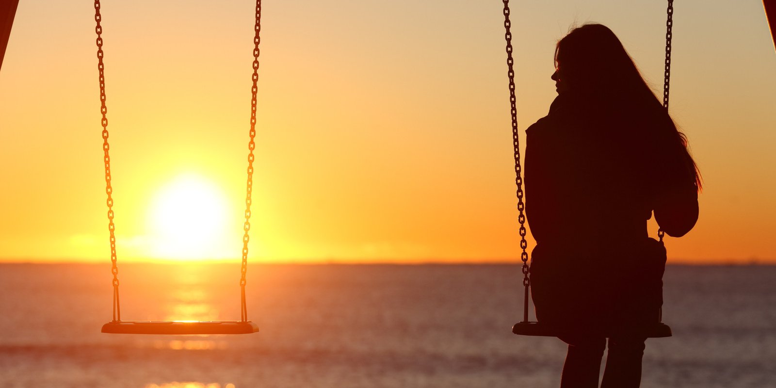 Single woman alone swinging on the beach