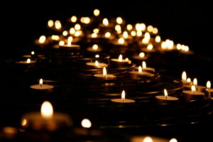 Photo by Mike Labrum on Unsplash Warm candlelight flickering in the dark, representing sacred space for grief, psilocybin retreats, and safe emotional processing through legal psychedelics.