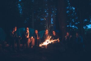 Group gathered around a campfire at night, symbolizing support and integration after challenging psilocybin experiences in Oregon