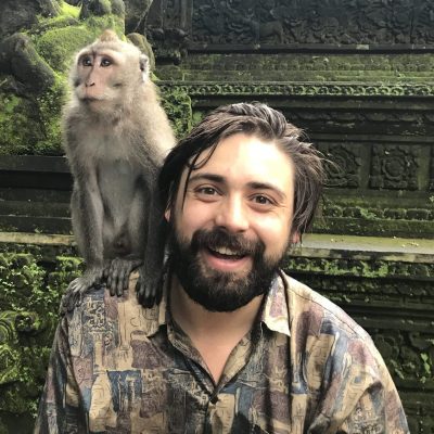 Psilocybin Oregon facilitator Jadryn smiling with a monkey perched on his shoulder, known for supporting deep psilocybin experiences that help with Treatment-Resistant Depression, PTSD, OCD, and major life transitions. Based at Vital Reset, he brings trauma-informed care and personalized psilocybin treatment with sliding scale pricing.